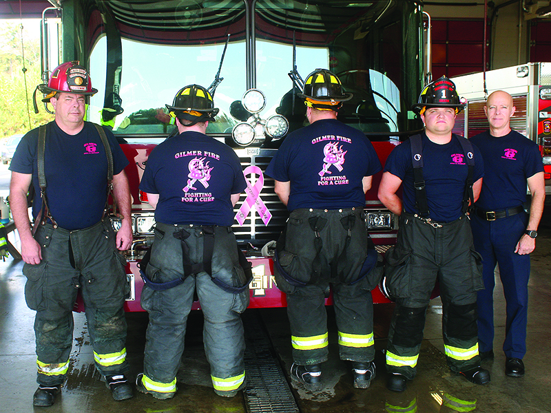 Gilmer Public Safety staff give a front and back look at fundraising T-shirts worn in observance of Breast Cancer Awareness Month. Pictured from left: Chris Bird, Caiden Osborne, Bobby Padgett, Dakota Heath and Fire Chief Daniel Kauffman.  