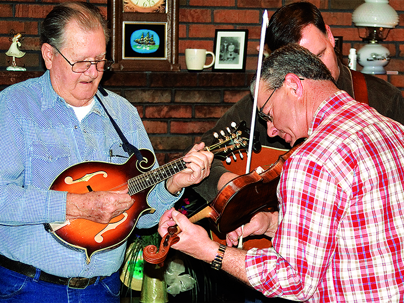 Chancey, left, picks the mandolin alongside bandmates Wayne Wright, in back, and Jerry Hensley, right, during a get-together at his home in 2010. 