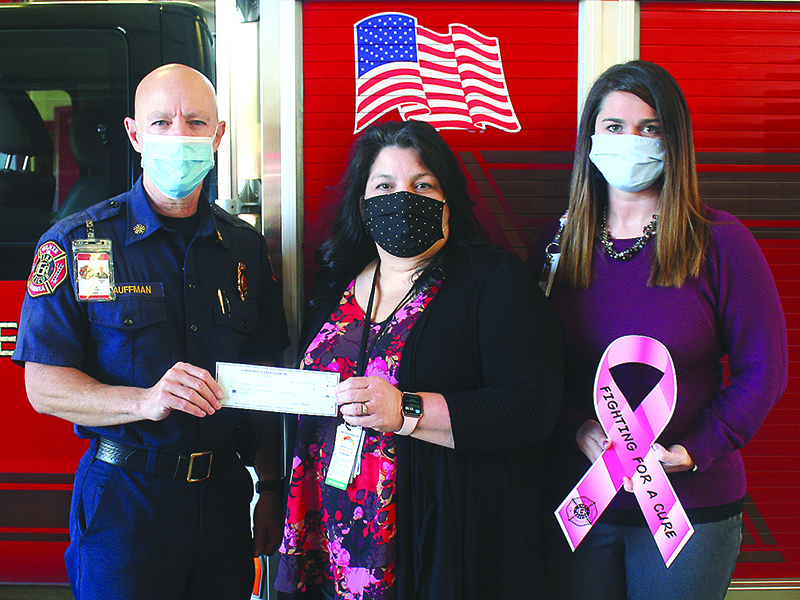 Gilmer County Fire Chief Daniel Kauffman presents a check from the public safety agency’s recent Fighting for a Cure fundraiser to Piedmont Mountainside Radiology Clinical Manager Jennifer Nestor, center, and Piedmont Mountainside Director of Imaging Services Brandi Baldwin, right. The funds will be used to provide reduced-cost mammograms for 13 local women.