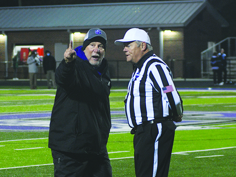 GHS coach Kevin Saunders discusses the finer points of officiating with the head referee last Friday.