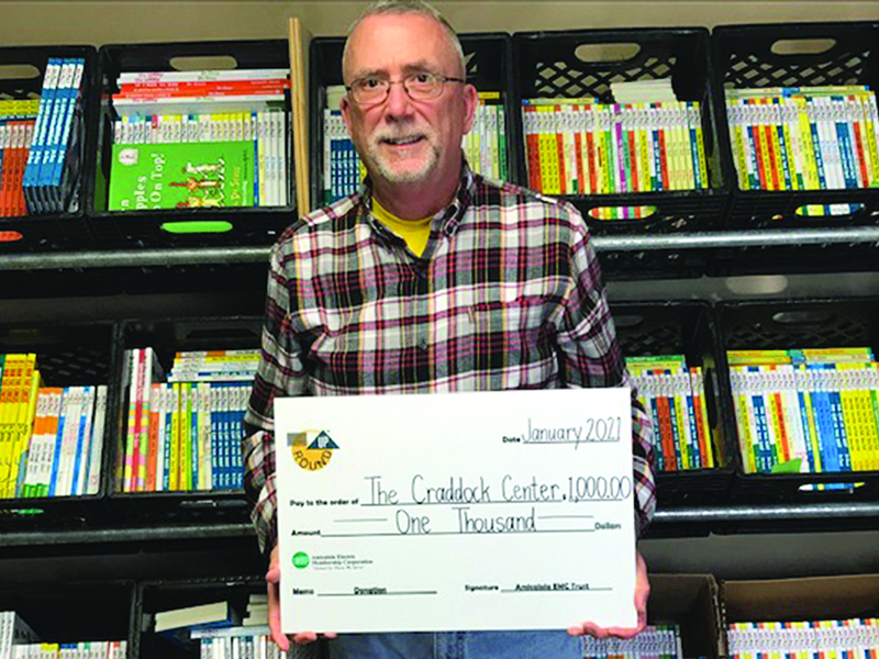 Craddock Center Executive Director Kirk Cameron holds a $1,000 check from Amicalola Electric’s Operation Roundup program used to buy books for an upcoming Dr. Seuss program at area schools.