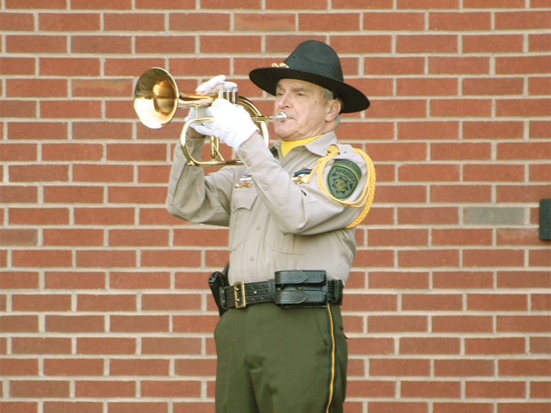 Bugler Bill Hall plays “Taps” to conclude the ceremony. 