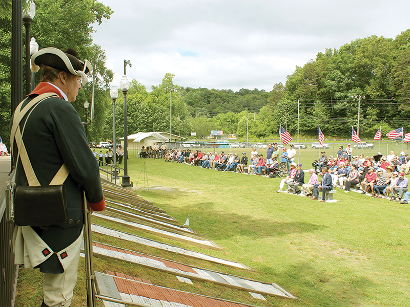 An unnamed veteran wearing the Revolutionary War uniform of a Colonial soldier stands sentinel over more than 200 attendees at Monday’s Memorial Day service.