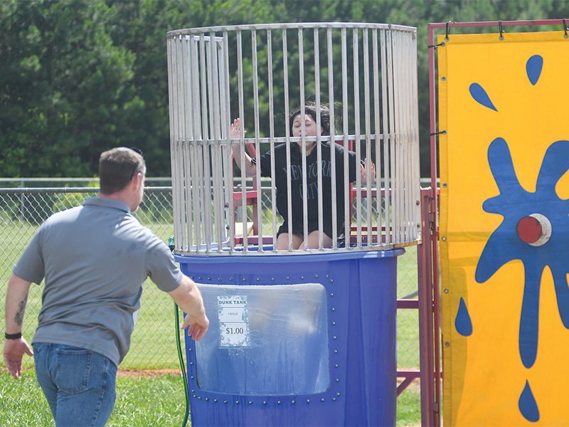 It was all for a good cause as Deputy Zach Weaver takes a throw at the dunk tank, in which his daughter, Sara Weaver, sits. The dunk tank was among the event’s fundraising activities.