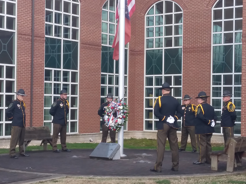 An honor guard comprised of Gilmer Sheriff’s Office personnel encircles a red, white and blue wreath placed at a marker at the base of the courthouse flagpole honoring Dickey. Pictured, from left: Al Greenway, Randy Beavers, Josh Easley, Greg Dotson, Jeff Ellington, Brian Crump and Ryan Scott.  