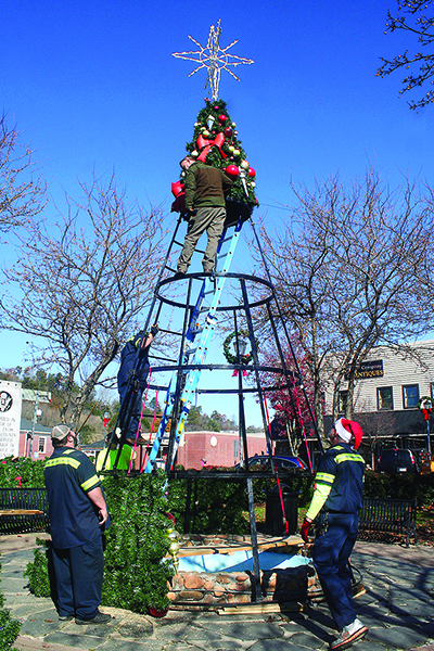 Steven Morris, Tony Teague, Chris McDaniel and David Fisher, all of the City of Ellijay Street Department, and volunteer Bobby Cloer, on ladder, put together the Christmas tree on the downtown square Monday morning in preparation for this year’s Light Up Ellijay festivities. 