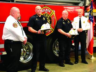 Eric Irish, second from left, and Mike Dempsey, third from left, receive their battalion chief hats from Deputy Fire Chief Mark Chastain, left, and Fire Chief Daniel Kauffman, right.