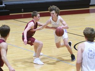Bobcat Braden Jenkins (right) works on getting past a Lion defender in the opening round of the Carpet Capital Christmas Classic last Friday.