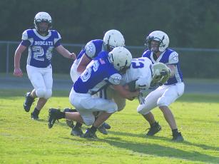 From left, Clear Creeks’s Hunter Britain (6), Michael Bushey and Cheyne Smith make a tackle versus Lumpkin as Blake Grizzle (24) runs to assist.