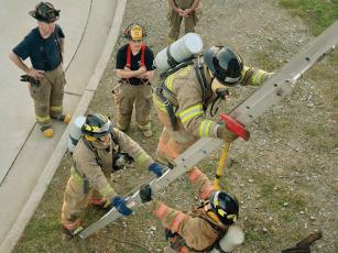 Gilmer County firefighters and recruits are shown during a training exercise on how to safely enter and exit a burning building using a ladder. (Photos by Al Cash/ Gilmer Fire and Rescue)