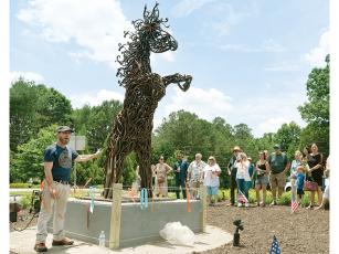 Ellijay sculptor and blacksmith Eric Strauss speaks about his piece “Entwined Strength” during a recent dedication ceremony in Johns Creek. The steel horse sculpture is the centerpiece of a roundabout in the Shakerag community of Johns Creek.  