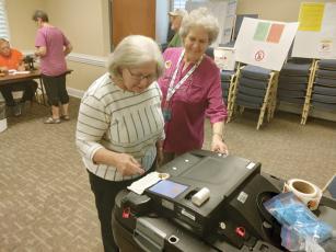 East Ellijay Poll Manager Kathy Watkins, right, helps voter Sally Forest turn in her ballot to be recorded during the runoff election held Tuesday, June 21.  