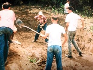 At an archaeological dig during the construction of Carters Dam in the mid-1960s, the man in the checkered shirt may be Dr. A. R. Kelly of the University of Georgia, with high school students who helped with the unearthing of relics. Regional historian Greg Cockburn said it appears from the photo that layers below the original ground level of the village are being removed. “I also remember the circle they painted on the rocks that’s in one of the photos in the 1963 Red and Black article,” Cockburn said.