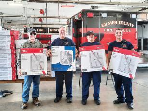 Faith, Hope and Charity Recycle Store volunteer Phil Welsh, left, delivers box fans to Gilmer County firefighters Steven Crenshaw, Alicia Wingfield and Adam Gravitt.