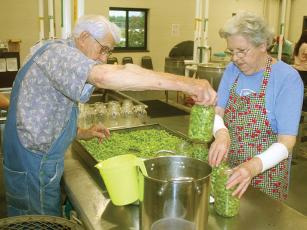 Otis and Shirley Suddeth work on getting their “cornfield” green beans in jars at the Gilmer County Cannery. 