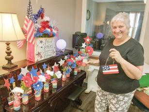 Joan Alford, Gilmer Senior Center activities coordinator, shows some of the Independence Day crafts recently made by senior center attendees.