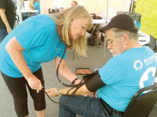 Mary Young, who has worked as a registered nurse and is a Bethesda Community Mobile Clinic volunteer from Hope Lutheran Church, of Ellijay, takes a man’s blood pressure on the third Wednesday of August.  