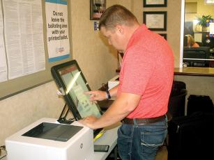 Gilmer County Elections tech Dustin Long conducts logic and accuracy testing on one of the county’s voting machines. 
