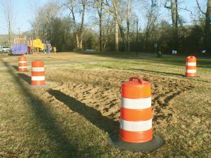 Orange barrels mark where a Daffodil Project garden will soon be planted at River Park. 