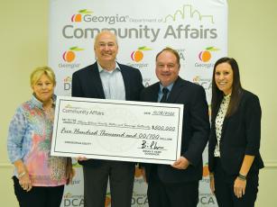 Gary McVey, Ellijay-Gilmer County Water and Sewerage Authority director, third from left, accepts a $500,000 OneGeorgia Equity Grant from Christopher Nunn, Georgia Department of Community Affairs (DCA) commissioner. Also pictured are Georgia State Representative Penny Houston, left, and Gina Webb, of Georgia DCA, right. 