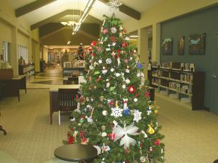 The public is invited to check out the Gilmer County Library’s 2022 Festival of Trees and enjoy other activities at an upcoming holiday open house. Pictured is the Garden Club of Ellijay’s Festival of Trees entry, which features recycled “trash to treasure” ornaments. 