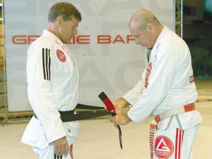 Kerry Sweat, left, receives his black belt in Brazilian jiu-jitsu from Master Carlos Gracie Jr. during a graduation ceremony at the Gracie Barra headquarters in Florianópolis, Brazil. 