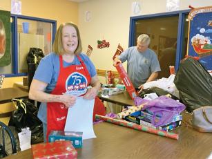 Volunteers Victoria and John Bateman are shown helping wrap gifts for the 2022 Gilmer County Toys for Tots campaign.