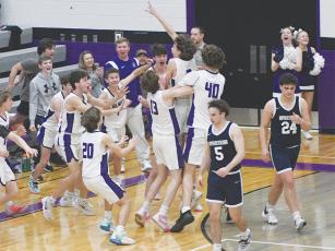 Gilmer’s Myles McCall (13), Jackson McVey (40) and the rest of the Bobcats celebrate with junior Ryder Wofford following his game winning shot for a 67-65 win over the dejected West Hall Spartans.