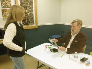 Ellijay Northeast poll manager David Strickland helps voter Karen Ingersoll during the educational sales tax special election last Tuesday.