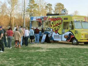 Attendees line up to try a Super Taco at the first Food Truck Tuesday held at River Park March 7. Super Taco “El Guero,” of Atlanta, was one of several local and regional food trucks that participated in the new event, which will continue at the South Main Street park the first Tuesday in April. 