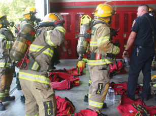 Gilmer Fire Battalion Chief Jason Bryant, right, observes the progress of recruits in training as they work toward donning their protective gear in two minutes or less.