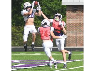 Rising Gilmer High senior Ian Berry catches a touchdown pass from quarterback Issac Rellinger in last Wednesday’s intrasquad football scrimmage.
