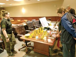Sgt. Lessie Sippel, of the Gilmer County Sheriff’s Office, left, shows Citizens’ Law Enforcement Academy class members some of the items, like evidence placards, that are used by the local criminal investigations team. 
