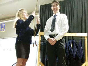 Ian Haggerty, shown accepting his graduation cord from Olivia Shull, was among the senior Gilmer High School FFA members who hung up their blue jackets at the 2023 FFA Banquet held last week at the Clear Creek Agriculture Education Center.