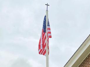 A new American flag flies following a flag retirement ceremony at Good Samaritan Catholic Church on Flag Day, June 14.