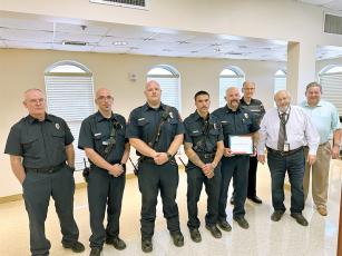 Gilmer County Commissioners recognize members of a Gilmer EMS crew that successfully transported a patient who’d gone into cardiac arrest to a hospital in Cherokee County. From left: paramedic Kevin Garren, paramedic Phillip Boyle, EMT Geoffrey Daves, AEMT Aaron Cannady, EMS Chief Terence Evans, Post 1 Commissioner Hubert Parker, Commission Chairman Charlie Paris and Post 2 Commissioner John Marshall.