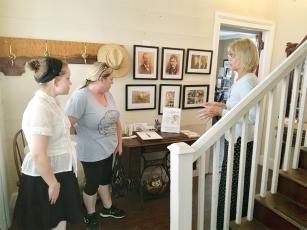 Museum volunteer Karen Vitelli, right, shows an exhibit on the Tabor family to Audrie York, left, and Charity Meints, center, of downtown Ellijay’s A Little Baked Bakery. 