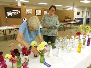 Ellijay Lions Susan Harden, left, and Ruthann Harding, right, award ribbons to the winning floral entries.