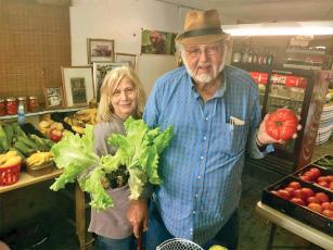 Sue and Walt Taylor show some of the fresh fruits and vegetables that have made Paw Paw’s Produce a popular roadside business. The future of the produce stand is uncertain after new spots the Taylors planned on moving to did not work out for various reasons. 