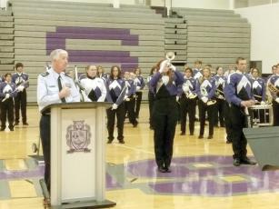 Program host Ret. Air Force SMSgt. Sam Burrell and members of the Gilmer High School Band stand in recognition as GHS bugler Madison Lyles plays “Taps” to conclude an honorary Veterans Day program last Friday.