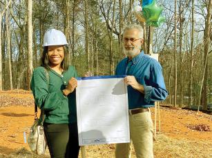 New Habitat For Humanity (HFH) homeowner Isha Davis, left, receives official home plans from Jeff Jackson, Fannin-Gilmer HFH house leader, during a recent groundbreaking for a Habitat home to be built in Gilmer County.