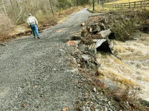 Gilmer County Road Crew Supervisor Ronnie Chadwick takes a look at Evans Road after creek waters came up over it during a heavy storm last week. 