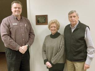 Patrick McVey, president of the Ellijay-Gilmer County Library Foundation, left, presents a plaque to Anne and Lex Rainey, center and right, dedicating a portion of the facility’s lower level to the longtime supporters of the local public library. 
