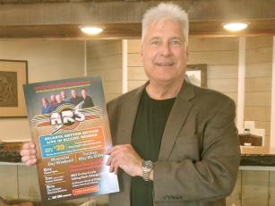 Promoter Ray Green holds a poster for the Atlanta Rhythm Section concert, which will take place Memorial Day weekend. 