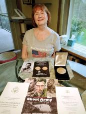 Janice Blanchard and her husband, Bill, traveled to Washington, D.C., in March to see her father’s unit be honored with a Congressional Gold Medal. However, after Janice tested positive for COVID, they watched the ceremony online. Here she displays some of the memorabilia of her father, Jack Stanley, who died in 2012.